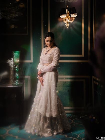 A full-length portrait of the bride against a dark, ornate wall. The soft, misty effect gives the image a dreamy and ethereal quality.
