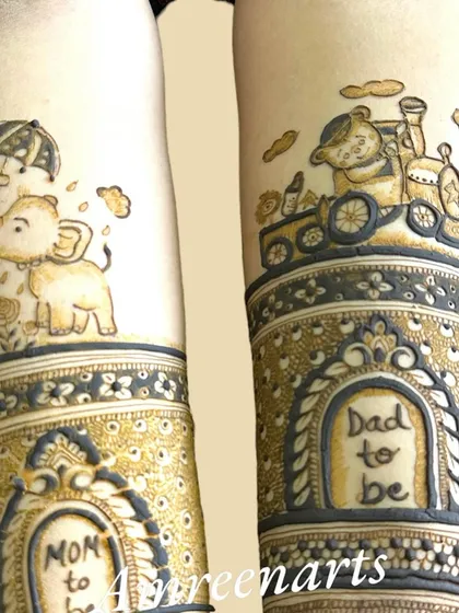 A close-up of the arm details for a baby shower mehandi. This shows adorable motifs like a baby elephant under an umbrella and a toy train with a teddy bear.