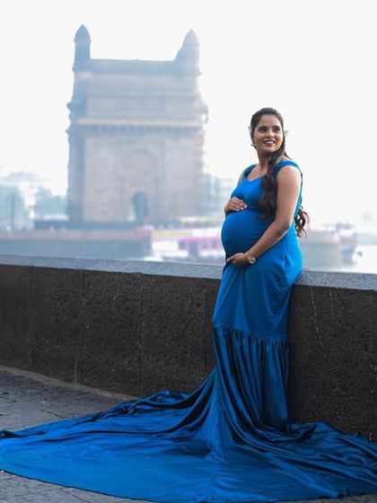 A stunning shot of a mom-to-be by the sea. The long trail of this royal blue maternity gown adds a touch of elegance and drama to the Mumbai cityscape.