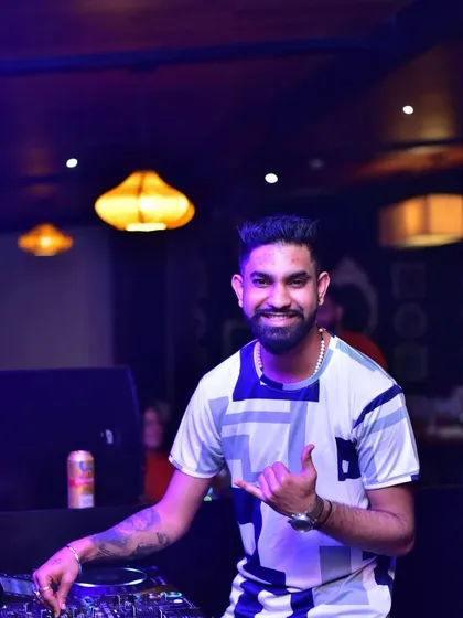 Giving the shaka sign to the crowd. It's all about good vibes and sharing the energy from the DJ booth to the dancefloor.