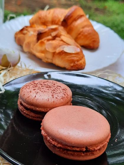 Our macarons and croissants, a perfect pairing. This user-submitted photo captures the simple joy of enjoying our handcrafted goods.
