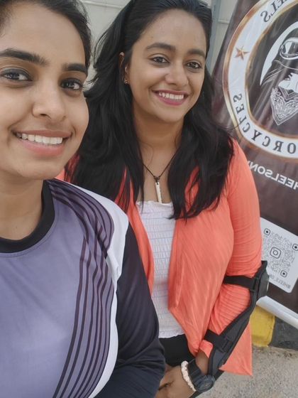 Two graduates in front of our banner. They are now ambassadors of the Heels on Wheels spirit.