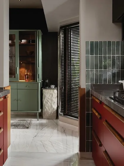 Color can completely transform a kitchen's mood. The deep Marsala red of these cabinets, paired with dark stone and green tiles, creates a space that is bold, warm, and full of personality. It’s a confident design for a home with a story to tell.