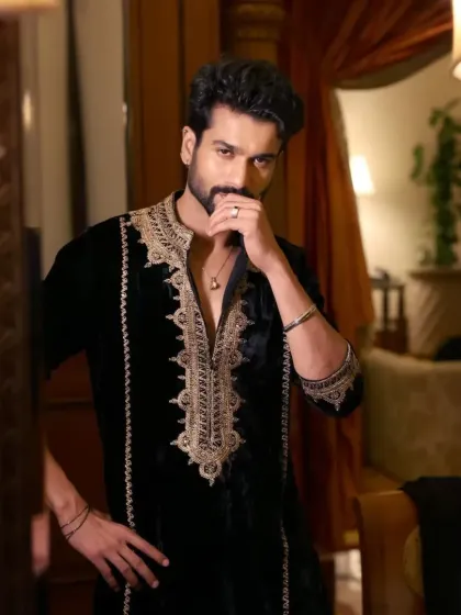 A black velvet kurta with rich copper-gold embroidery around the neckline. The velvet fabric makes it a luxurious choice for winter festivities.