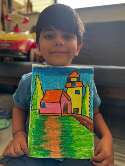 A first-grade student shows his charming landscape drawing of a house and a tower. We focus on building scenes from simple shapes, making it easy for young artists to create their own worlds.