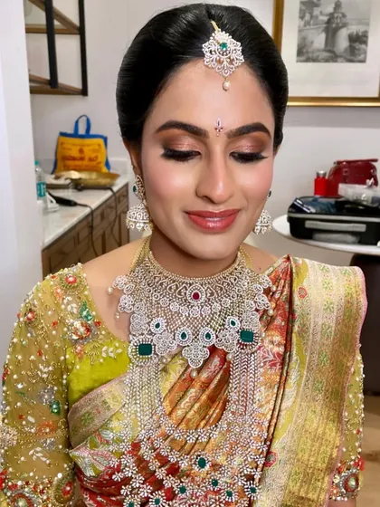 A classic wedding day look with a touch of glamour. The bronze and gold smokey eye pairs beautifully with her ornate jewelry and saree.