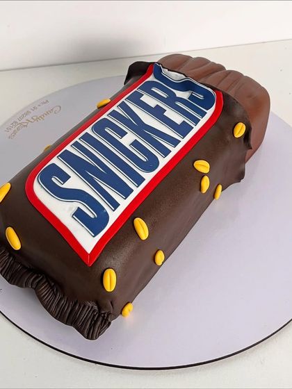 A full view of the impressive, life-like Snickers bar cake.
