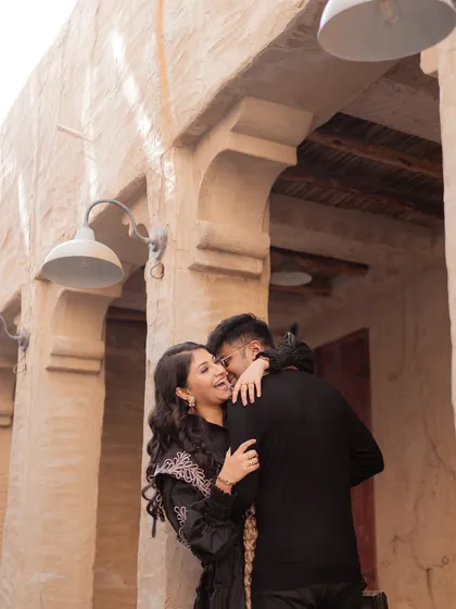 An embrace filled with laughter and joy. This close-up captures the genuine connection and happiness of the couple amidst the beautiful architecture of old Dubai.