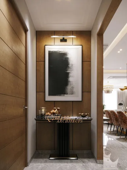 A sophisticated entryway featuring a wood-paneled wall, abstract black-and-white art, and a minimalist console table, setting a tone of modern elegance.