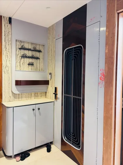 The complete foyer area, including the chevron-patterned door and a matching shoe cabinet with a nameplate and shelf.