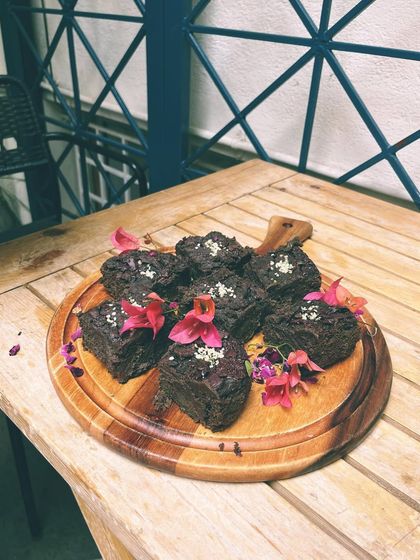 A tray of our decadent chocolate brownies, garnished with edible flowers. Perfect for catering or just a treat for yourself.