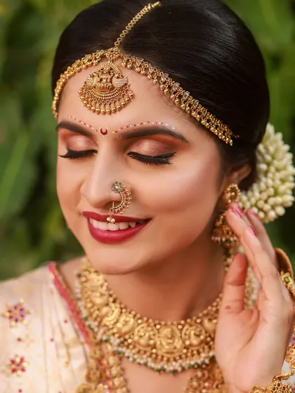 A close-up of a Konkani bride, her eyes closed in a serene expression, highlighting the traditional bindi and subtle makeup.