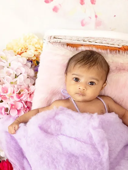Capturing a baby's curious, wide-eyed gaze is so special. For this shot, I created a bed of soft, colorful flowers to frame her beautiful expression, resulting in a vibrant and engaging baby portrait.