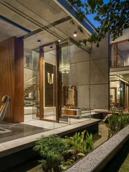 Our design for the puja room reimagines a traditional space in a contemporary context. Enclosed in glass and positioned over a water body, it becomes a tranquil sanctuary, with a custom titanium panel featuring a sacred shloka.