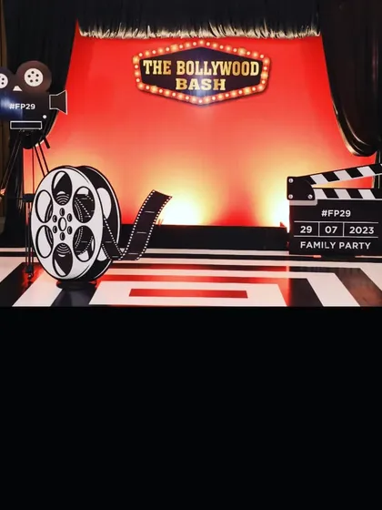 A custom photo booth designed for 'The Bollywood Bash,' a corporate family party. We create engaging, themed installations like this, complete with props like a film reel and director's clapper, to provide guests with fun, memorable interactions.