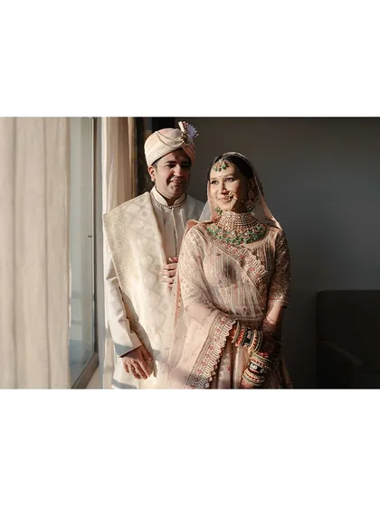The couple sharing a smile by the window, the natural light creating a soft and romantic mood.