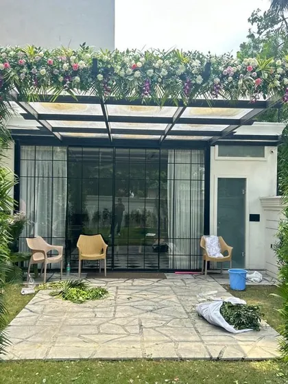 We also decorate outdoor spaces like patios and pergolas. Here, we covered the structure with a thick arrangement of mixed flowers and greens, creating a beautiful setting for a garden party or daytime event.