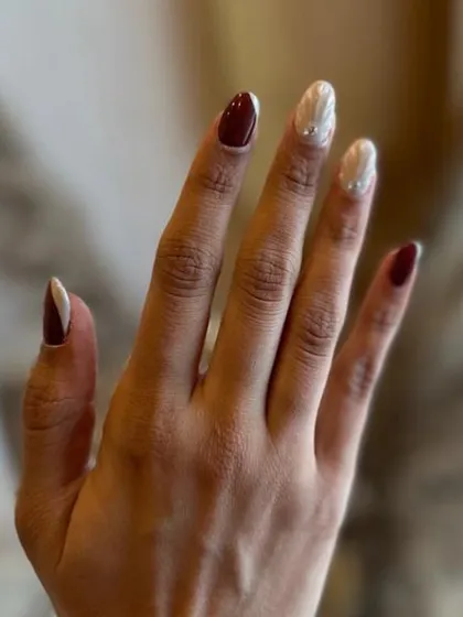 A full hand view of the pearly white and wine-red nail set. The contrast is simply stunning.