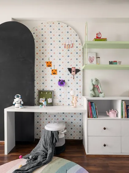 This playful study nook features a polka-dot pinboard and a chalkboard arch for creative expression. The open shelving and drawers provide ample storage for art supplies and books, keeping the space organized and inspiring.
