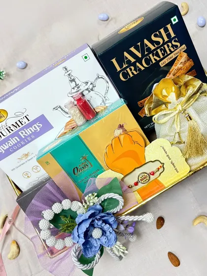 A beautifully decorated Rakhi hamper featuring Ajwain Rings cookies, Lavash crackers, and other treats. This gift is perfect for a sibling who enjoys a mix of sweet and savory.