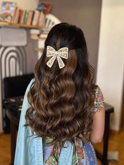 This angle highlights how the bow perfectly completes the half-up hairstyle, adding a touch of modern elegance.