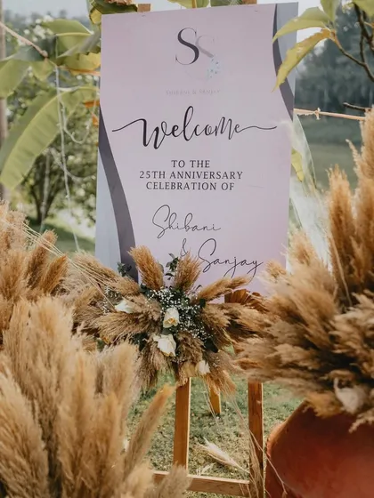 A welcome sign for a 25th anniversary, beautifully integrated with the pampas grass decor theme.
