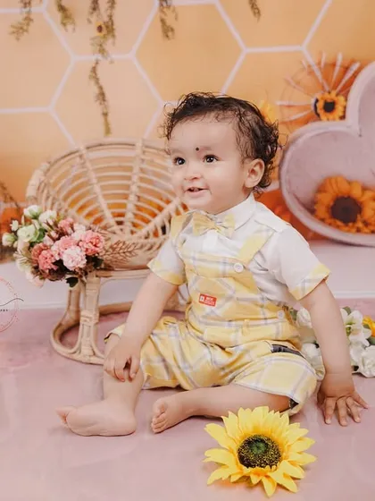 A happy, relaxed portrait of the birthday boy sitting amongst sunflowers, perfectly capturing the warmth of the theme.