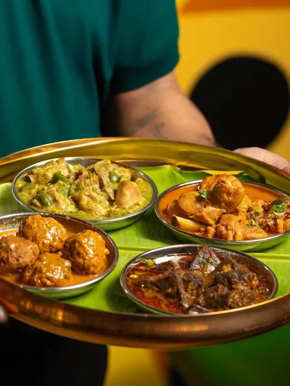 A platter showcasing the variety of my Naati curries. Here you can see different preparations, including my Khaima Unde Saaru and Mutton Chops, each with its own unique blend of spices and rich gravy.