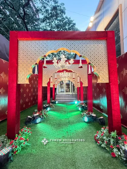 For a truly grand and royal statement, I designed this opulent red and gold entrance. The layered arches with traditional motifs, velvet textures, and brilliant chandeliers create an unforgettable first impression for a regal shaadi.
