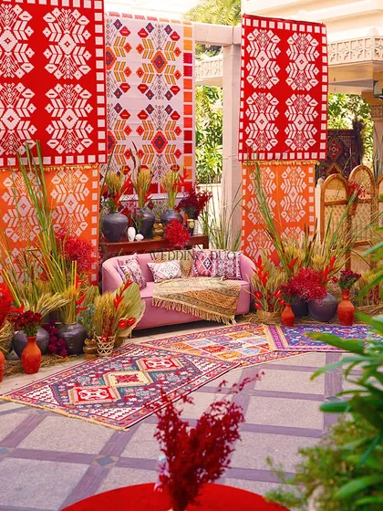 A full view of our vibrant Bhaat ceremony setup. The design is a rich tapestry of African-inspired prints, layered rugs, and lush, wild foliage, creating a truly unique and celebratory space.