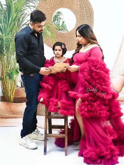 A candid moment during a family maternity session, where the parents and their daughter are looking at an ultrasound picture together. These unposed moments are often the most special.