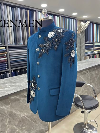 A side view of the teal velvet Jodhpuri, showing how the floral embellishments are strategically placed to create a dynamic and flattering design.