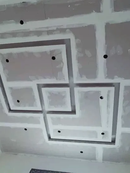 A maze-like geometric pattern being constructed with gypsum board. This shows the structural integrity of the design before it's smoothed over with POP.