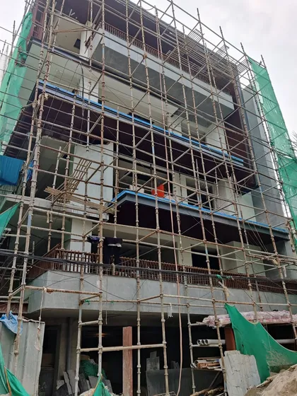 A residential building in progress, with scaffolding covering the facade as finishing work begins. Even at this stage, the "beauty" of the underlying design begins to emerge.