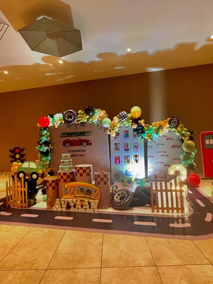 An action-packed car-themed birthday party. I transformed the space with a custom floor decal designed like a road, a large backdrop, and fun props like a fuel pump and traffic cones. The balloon garlands and character cutouts bring the whole racing theme to life.