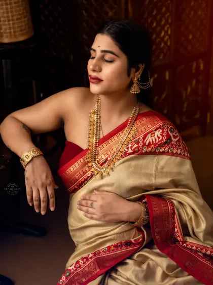 A serene and elegant close-up, showcasing the beautiful details of the traditional jewelry and the peaceful expression of the mom-to-be.