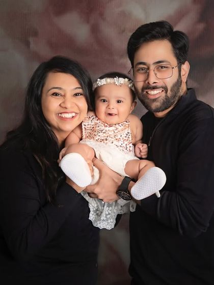 A bright and happy family portrait. The smiles are contagious in this beautiful photo against a soft, floral backdrop.