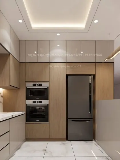Another view of the U-shaped kitchen, showing the tall unit for the refrigerator and the seamless integration of appliances. The false ceiling provides excellent task lighting.