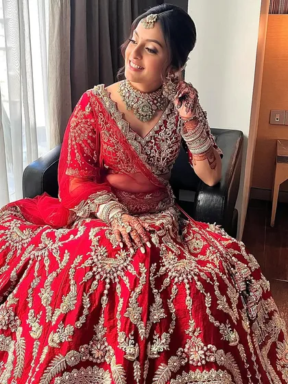 A joyful shot of the bride in her stunning red lehenga. The minimal glam makeup gives her maximum impact, letting her happiness be the focus.