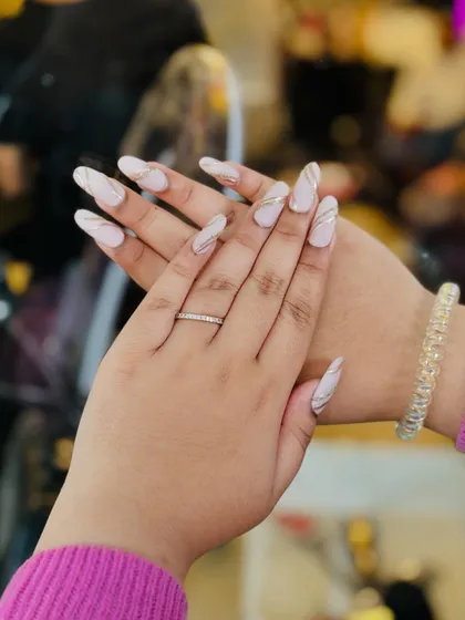 This pose showcases the full set of nails with sweeping gold lines, complemented by simple and elegant jewelry.
