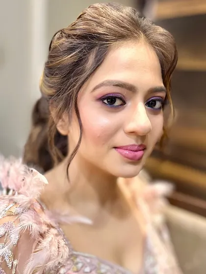 A balance of playful hues and refined elegance. This look features shimmering lids with a bold purple liner and juicy pink lips to complement her radiant glow, perfect for a fun sangeet.