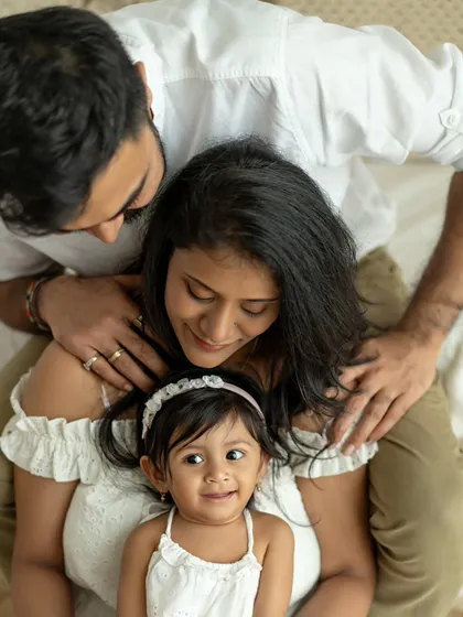 A high-angle shot of a family of three, looking up with love and happiness.