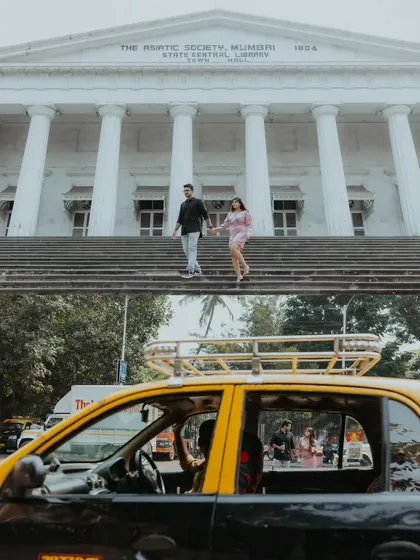 A dynamic two-panel shot showing the couple on the steps of the Asiatic Society Library, contrasted with a candid reflection in a classic Mumbai taxi, telling a story of the city.