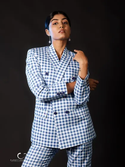 A strong, confident stance that showcases the full suit. The clean lines and bold pattern make a powerful statement against the simple black backdrop.