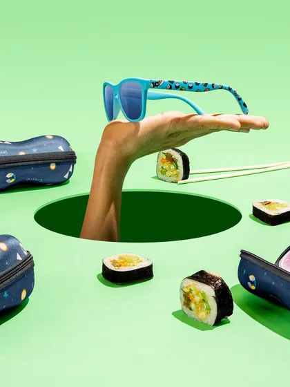 A fun and quirky concept for a sunglasses brand. The hand emerging from a hole, surrounded by sushi, creates a surreal and memorable image that perfectly captures a playful brand identity.