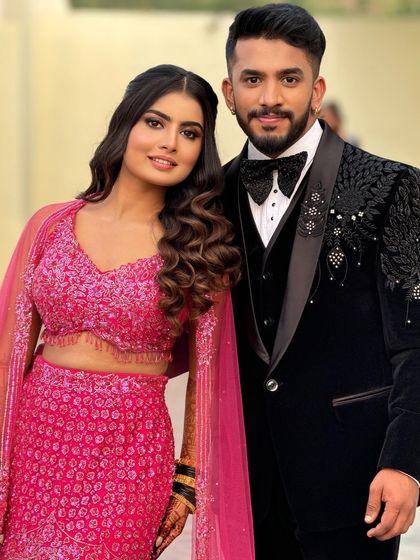 A classic couple portrait, showcasing their stylish reception outfits and the bride's glamorous makeup.