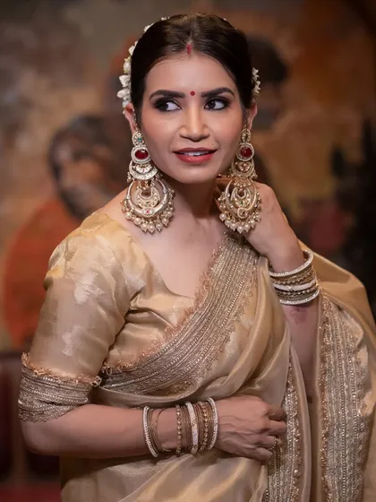 A close-up of the makeup for the Rekha-inspired look, featuring bold red lips and statement earrings.