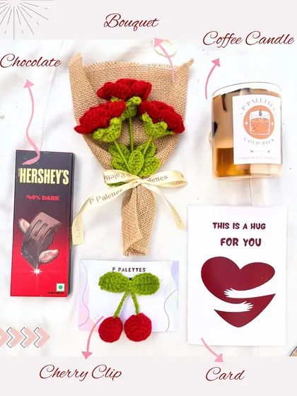 Our "Hug For You" hamper, featuring a dark chocolate bar, a handmade red rose bouquet, a coffee-scented candle, a cherry hair clip, and a sweet greeting card.