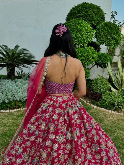 A view of the back of her outfit, showing the pretty halter neck blouse and the floral hair accessory.