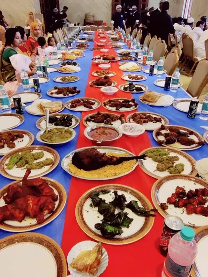 A colorful and abundant feast. The table is filled with a variety of non-vegetarian starters, curries, and biryani, showcasing the breadth of our menu.